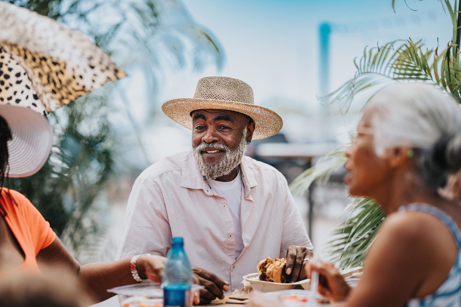Vibrant senior man enjoying local food with friends while in Hawaii